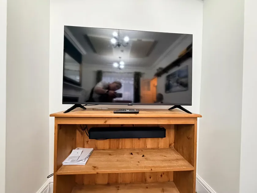 Television and soundbar on a wooden stand.